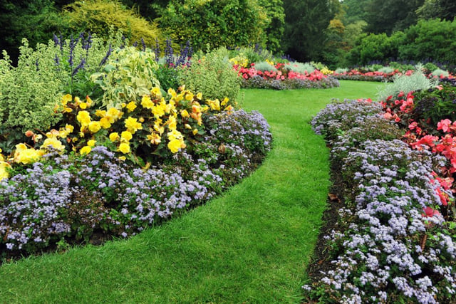 Jardim paisagístico com gramado, flores e caminho